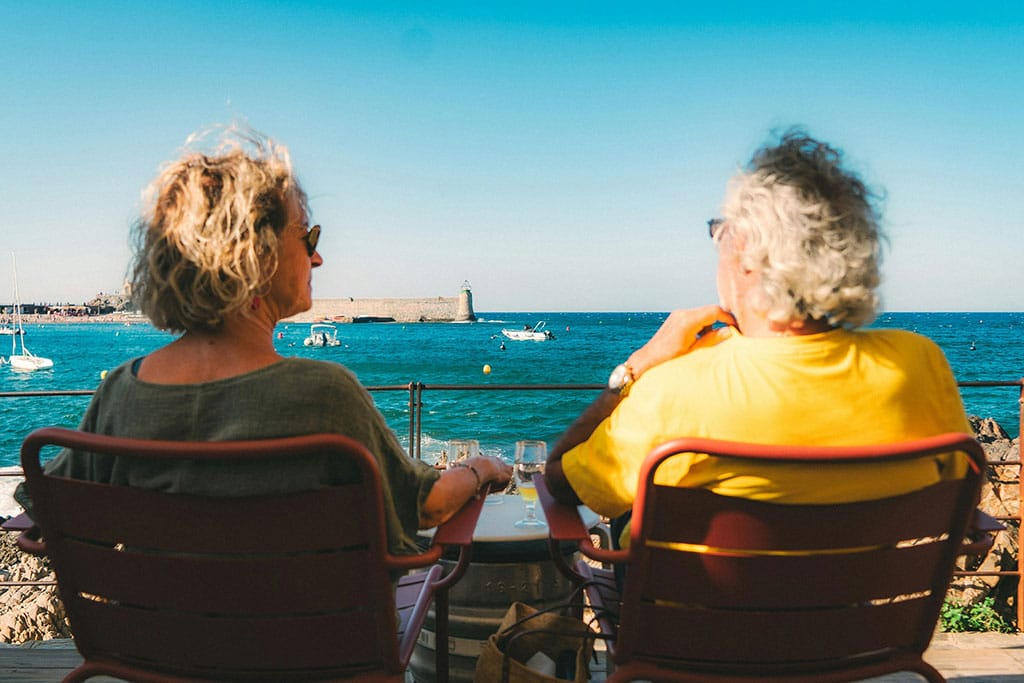 New Year, New Life in France: Financial Mistakes New Arrivals Make 1 Image of two people cat on chairs, looking out to sea, enjoying their new life in france