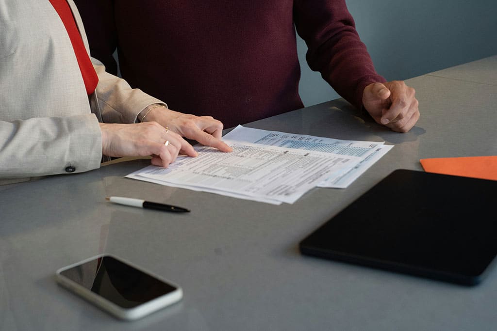 Completing Your French Income Tax Return: A UK Expats' Guide 1 Two people reviewing tax return forms at a desk.